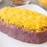 Molded ube halaya with cheese on a platter.