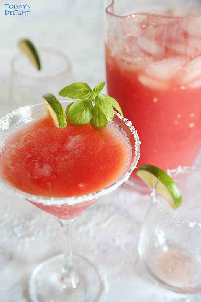 Refreshing Watermelon Juice in pitcher and cocktail glass with mint and a slice of lime.