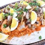 Filipino Noodle Dish topped with shrimp gravy and garnish