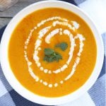 Kabocha Squash Soup with coconut milk and mint leaves at the center.