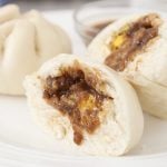 2 Siopao Asado (Filipino steamed pork buns) with sauce.