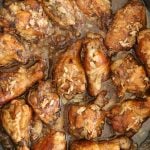 16 cooked chicken wings in adobo sauce in a skillet.