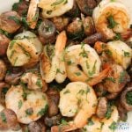 Sauteed shrimp and mushroom recipe with parsley and cilantro in a serving plate.