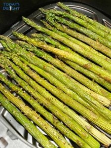 A bunch of seasoned asparagus cooked in air fryer.