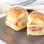 Two ham cheese sliders on a plate.