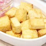 Sliced air fryer tofu with a side of vinegar and onion dip.