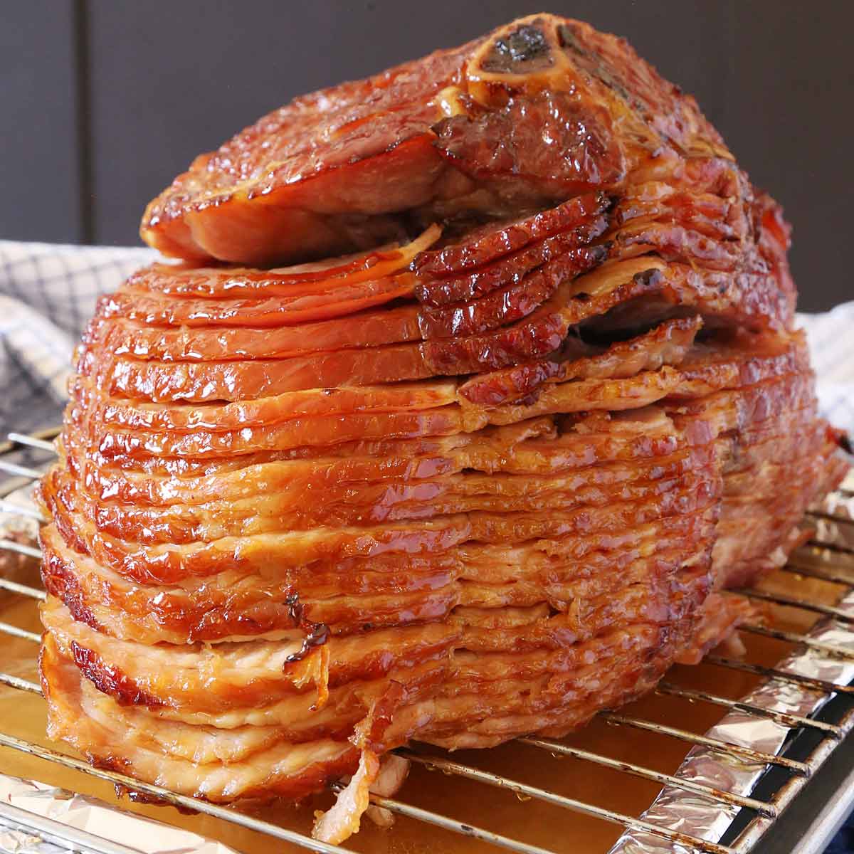 Baked spiral-cut honey ham on a roasting pan with rack.